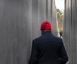 Tourist with red cap between the steles of the Holocaust Memorial