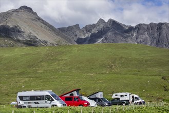 Motorhomes on camping at the foot of the Black Cuillin mountain range in Glen Brittle on the Isle of Skye
