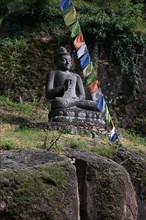 Buddha statue and Tibetan prayer flags in front of the entrance to the Messner Mountain Museum near Bolzano