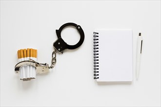 Top view notebook with cigarette handcuffs