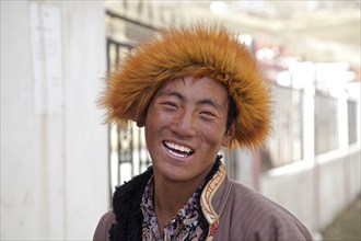 Close up portrait of smiling Tibetan man with fur hat in the village Qagca
