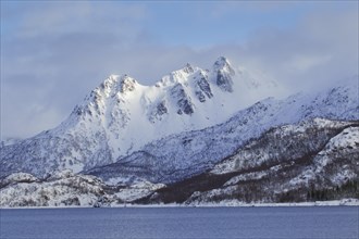 Snow covered mountains along the fjord Raftsund in winter