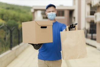 Medium shot delivery man holding box bag