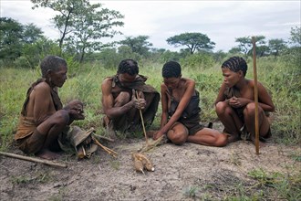 Bushman making fire by hand with wooden stick in the Kalahari desert near Ghanzi
