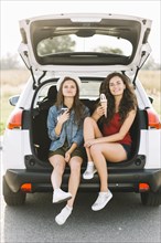 Women sitting car with ice cream
