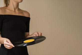 Young woman holding vinyl disk with copy space