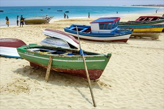 Colourful fishing boats moored on bright sandy beach