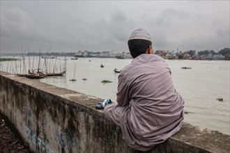 Boy sitting on a quay wall at Sadarghat