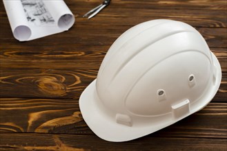 Flat lay construction helmet with plans background