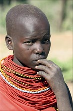 Portrait of young Turkana woman in traditional red clothing in northwest Kenya