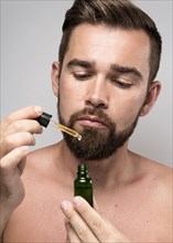 Man holding face oil bottle