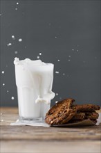 Milk splashed glass with cookies
