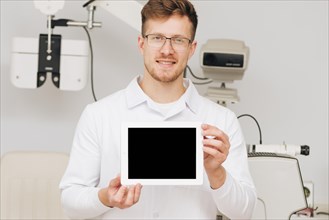Portrait male optometrist presenting tablet template