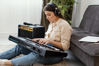 Side view female musician with headphones playing piano keyboard