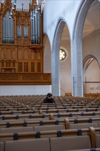 Woman Sitting Alone and Praying in St. Johann Reformed Church in Schaffhausen
