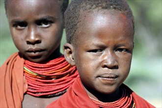Portrait of two Turkana children in traditional red clothing in northwest Kenya