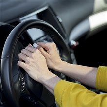 Woman resting her hands steering wheel