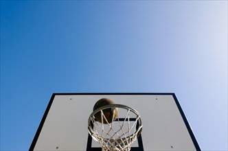 Basketball Hoop and a Ball Against Blue Clear Sky with Sunlight in Switzerland