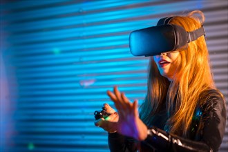 Woman gaming in a digital world using virtual reality goggles at night