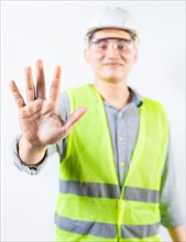 Young engineer counting number five isolated. Smiling engineer showing number five with hand isolated