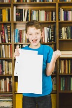 Happy boy showing paper with excellent mark