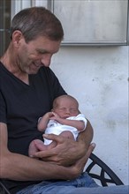 Young grandfather with his newborn grandson