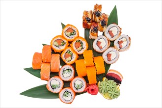Overhead view of big set of sushi rolls served on bamboo leaves