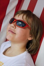 Young girl with sunglasses in beach chair