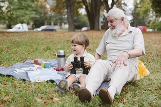 Grandpa grandson picnic with binocular