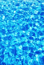 Water surface with light reflections in a swimming pool