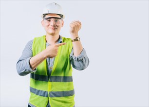 Smiling engineer pointing at his wrist watch isolated. Young engineer pointing and showing his wrist watch