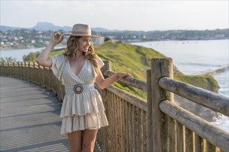 Portrait with copy space of a cute female model with summer clothes posing next to the sea