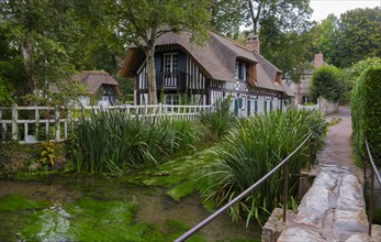 Half-timbered house with thatched roof on the river Veules