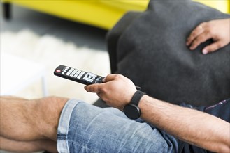 Close up man s hand holding television remote control