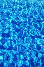 Water surface with light reflections in a swimming pool