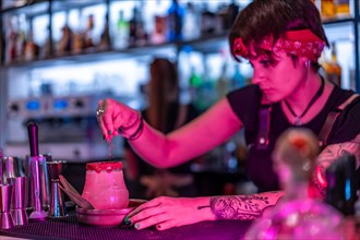 Bartender garnishing the top of a margarita cocktail in a bar