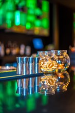 Vertical photo of an empty counter of a luxury bar at night with shot glasses