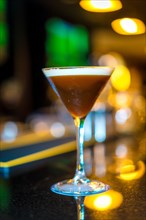 Vertical photo of a Martini cocktail on the counter of a luxury bar