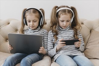 Cute twins using digital devices