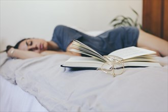 Glasses book near sleeping woman