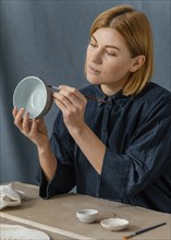 Medium shot woman painting bowl