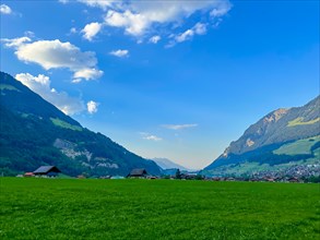 Beautiful Village in Mountain Valley with Blue Sky and Clouds in a Sunny Summer Day in Lungern