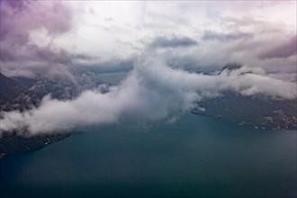 Aerial View over City and Lake Lugano in Valley with Mountainscape with Storm Clouds in Lugano