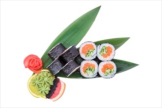 Overhead view of sushi roll with raw salmon fillet with cucumber served on bamboo leaves