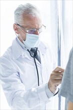 Doctor mask examining crop patient