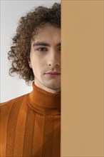 Curly haired man with brown blouse posing 7