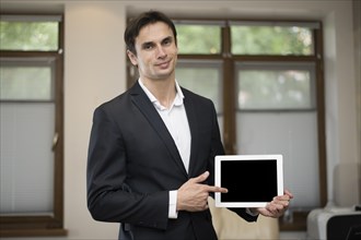 Medium shot businessman holding tablet