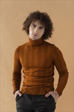 Curly haired man with brown blouse posing 3