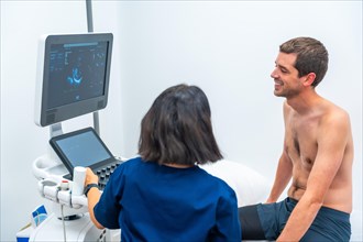 Female cardiologist doctor performing an echocardiogram on a patient in the hospital