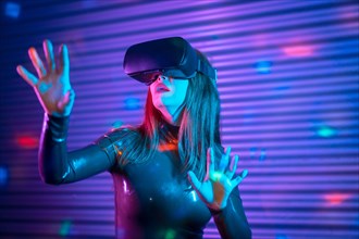 Female gamer wearing augmented reality goggles in a futuristic space with neon lights